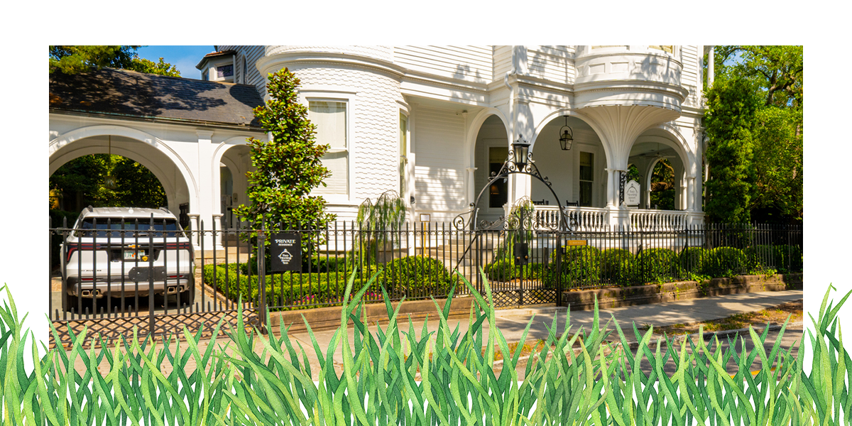 All white house with perfectly landscaped yard and trimmed hedges