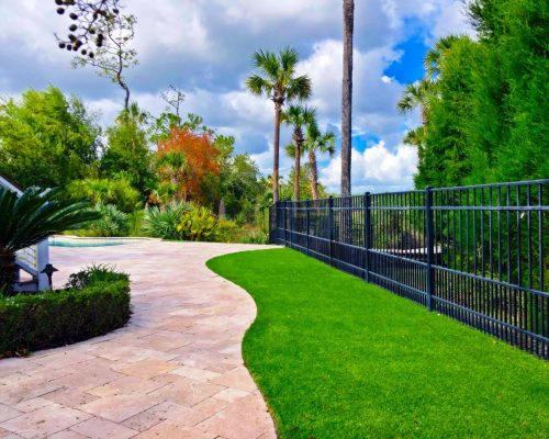 A luscious green lawn with grass and a patio